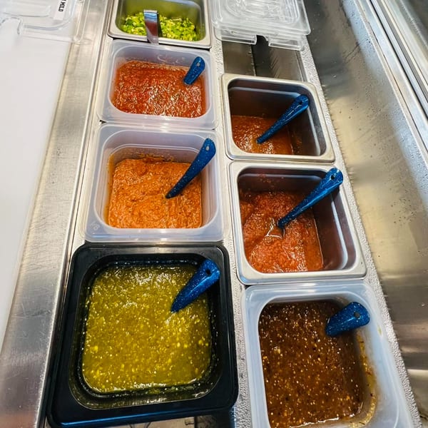 A variety of fresh salsas and guacamole in metal containers at Taqueria Monterrey.